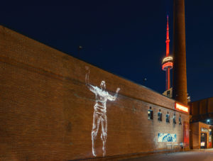 video projection of body on brick wall