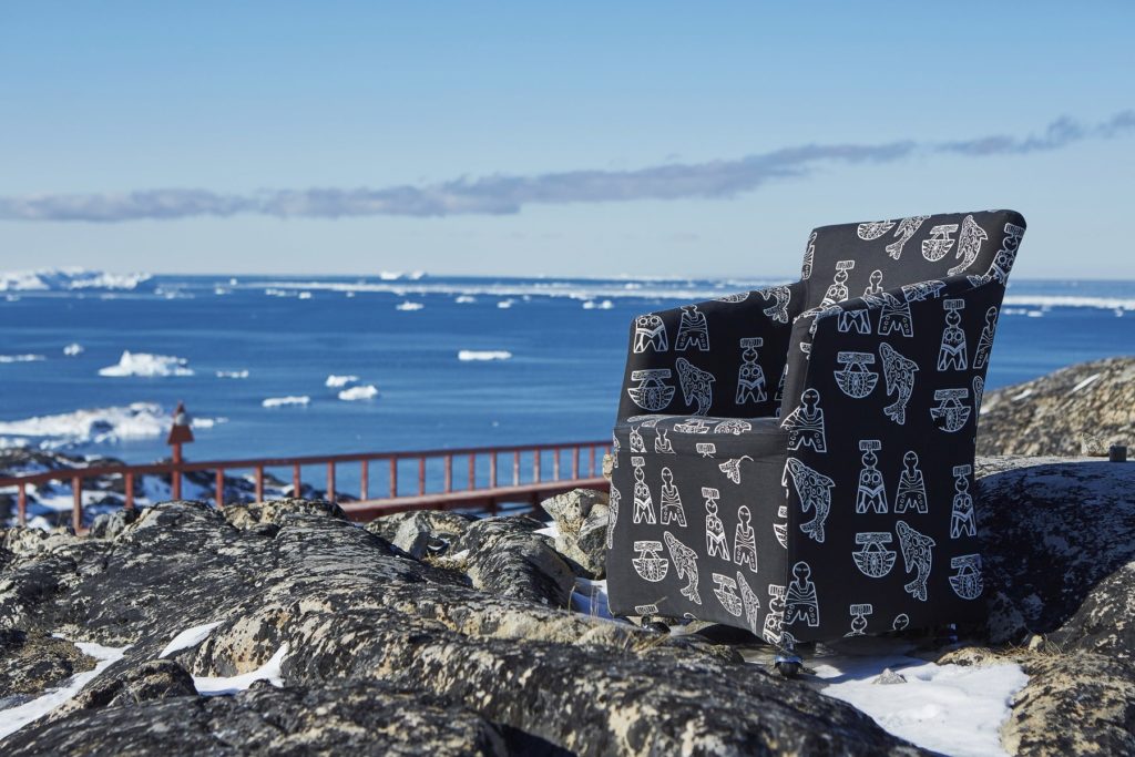 A chair with inuk designs positioned in front of the ocean