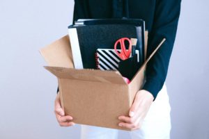 A person holding a box of office supplies