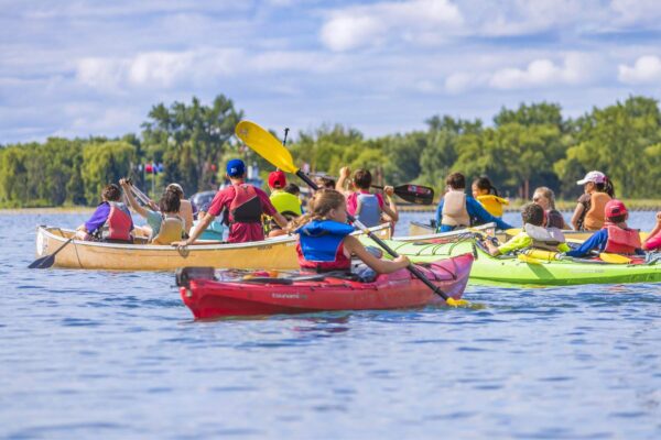 Kids in canoes and kayaks on the water