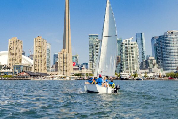 Kids on a sailboat on the water in the Toronto waterfront