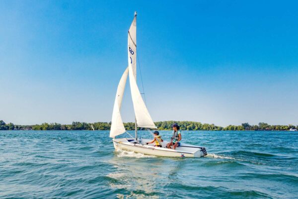Two kids on a sailboat on the Toronto waterfront
