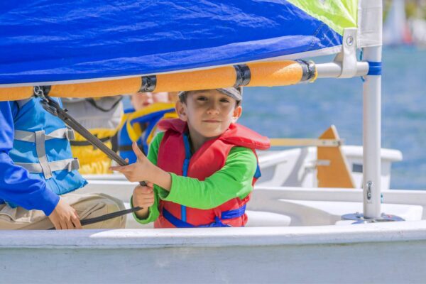 A kid in their sailboat on the water