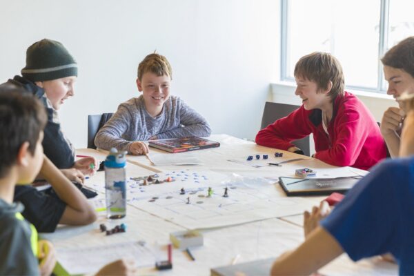 A group of boys play a board game at camp