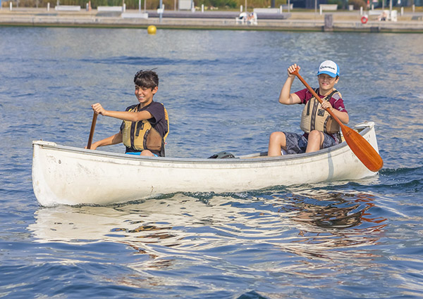 two kids in canoes on the water