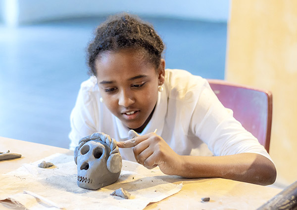 Kid working on their clay creation