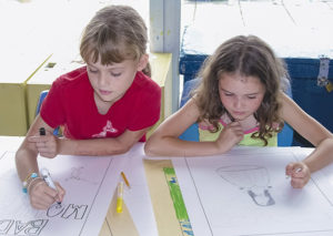 Two kids drawing comic pages