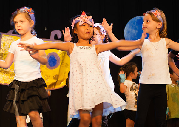 A group of kids dancing on a stage