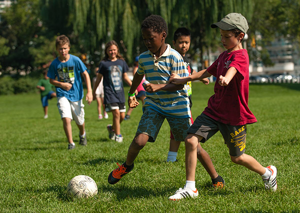 Kids playing soccer on a field