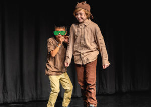 Two kids in costumes performing on stage