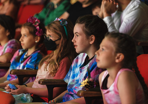 Kids watching a stage show in a theatre