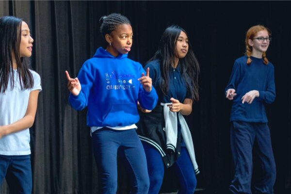 Group of students dancing in a theatre