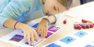A student works on a craft in a classroom