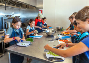 Kid chefs prepping food in a kitchen