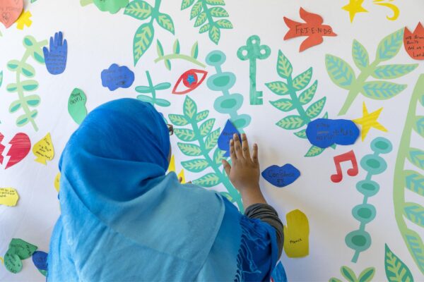 Artist wearing bright blue making art on the wall