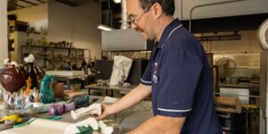 Artist working on glass work in studio