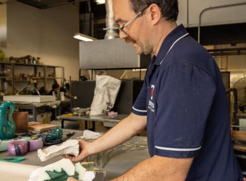 Artist working on glass work in studio