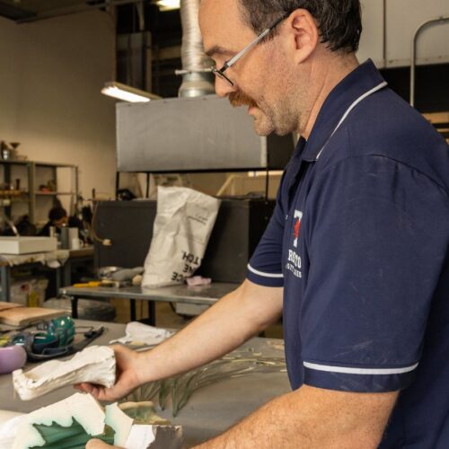 Artist working on glass work in studio