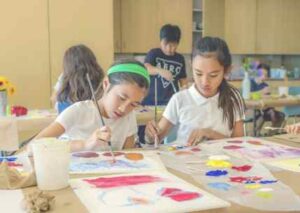 Group of girls watercolour painting in classroom