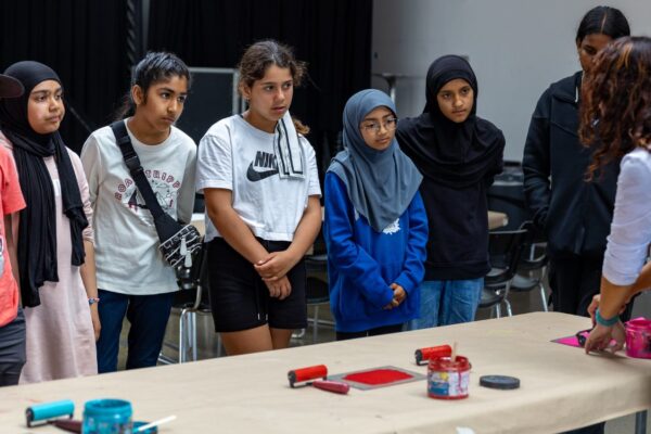 Group of students watching an instructor teach a craft activity