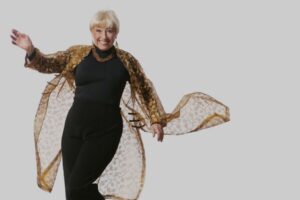 Woman wearing black clothes posing for the camera against a light background.