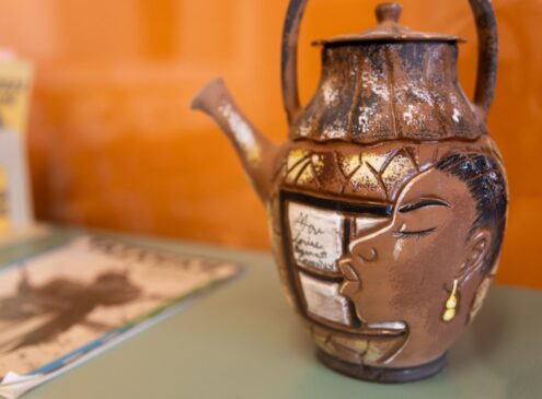 Ceramic pot with a portrait of Miss Lou sitting in a glass display.