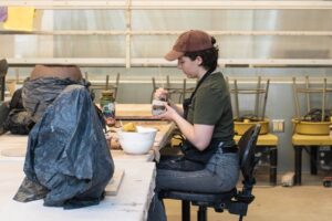 Woman working on a ceramic piece in a studio