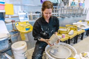 Woman working on a ceramic piece in a studio