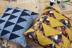 Two quilted pillows with a blue and yellow design