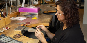 A woman making jewellery at a worktable