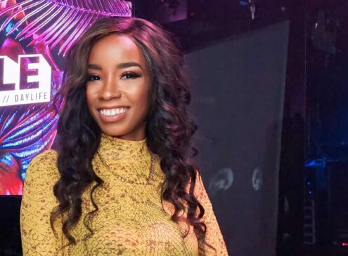 Woman wearing a yellow dress posing for the camera.