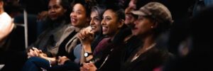Women sitting in a theatre smiling and clapping