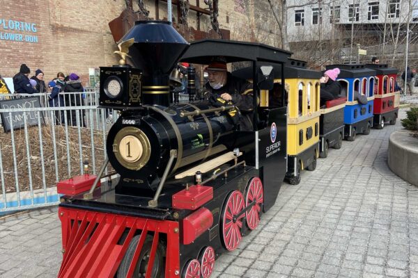 Black and red train operating outdoors during the holidays