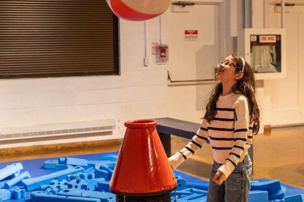 A girl playing with a ball in the air