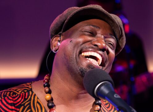 A singer smiling while performing.