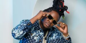 Man holding sunglasses posing for the camera.