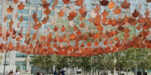 A colourful outdoor installation of copper leaves suspended in the air at Harbourfront Centre