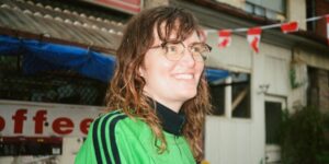 A woman wearing a green shirt looking into the distance