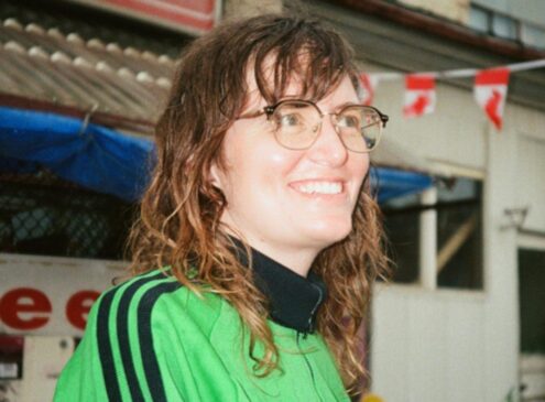 A woman wearing a green shirt looking into the distance