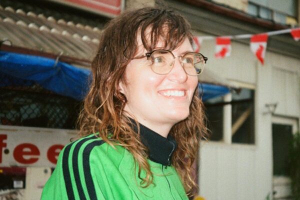 A woman wearing a green shirt looking into the distance