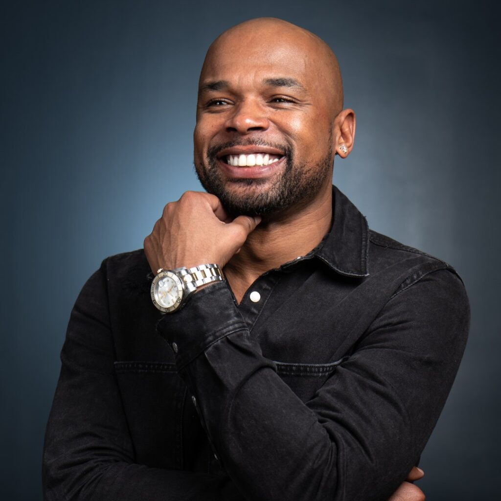 A man holding his chin with his hand smiling