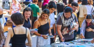 A crowd of people shopping at a local artists vendor market