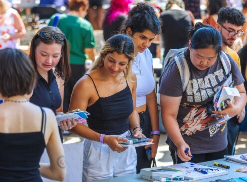 A crowd of people shopping at a local artists vendor market