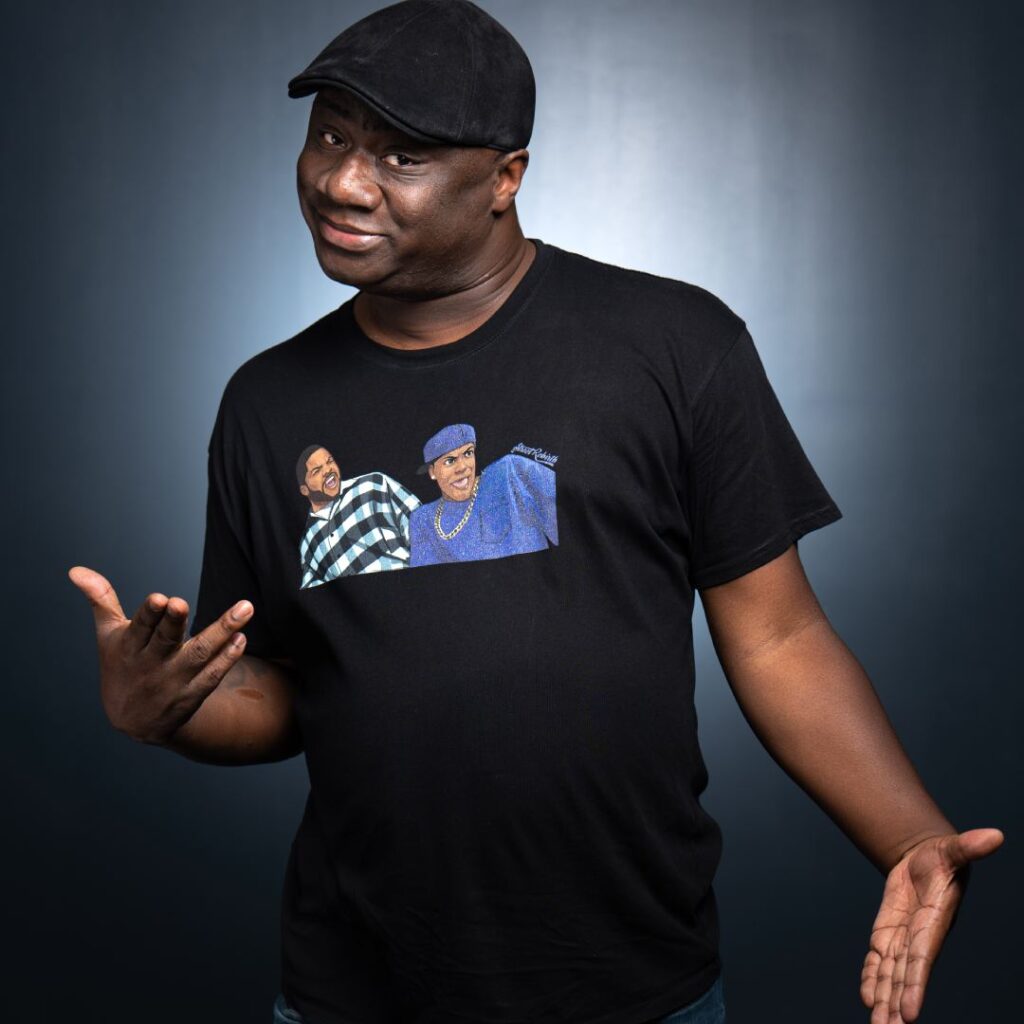 A man wearing a black shirt and hat posing for the camera
