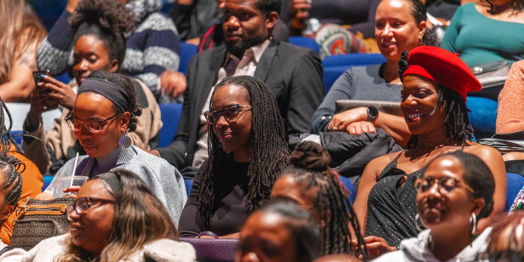 An audience sitting in their seats at a theatre
