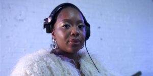 A woman wearing black headphones posing for the camera