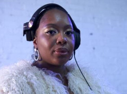 A woman wearing black headphones posing for the camera
