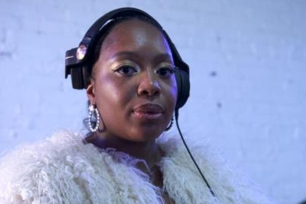 A woman wearing black headphones posing for the camera