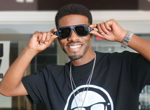 A man wearing sunglasses and a black shirt posing for the camera