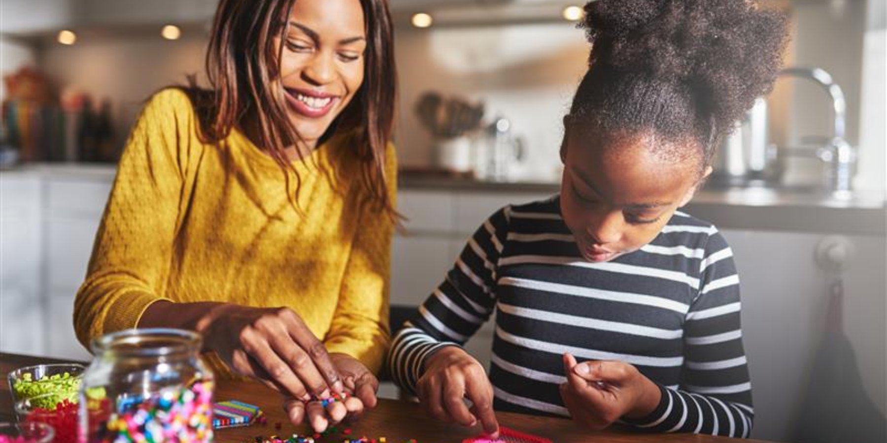 A mom and her daughter playing with arts and crafts at a table
